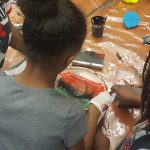 3 Black students at Grass Valley Elementary School in Oakland, CA participate in screenprinting together.