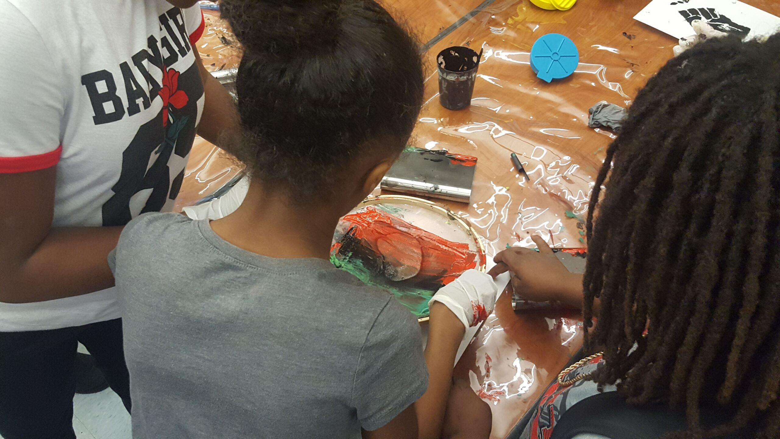 3 Black students at Grass Valley Elementary School in Oakland, CA participate in screenprinting together.